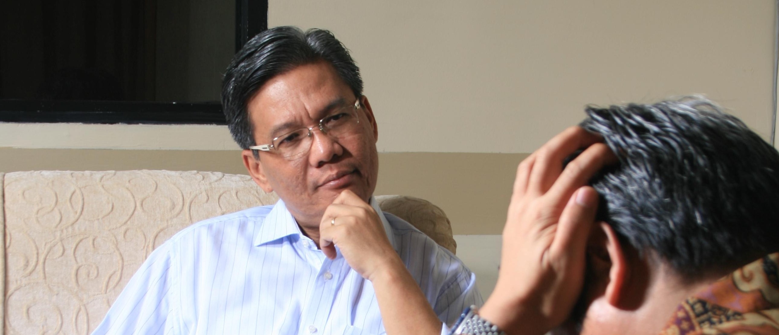 Two middle aged men talk and frown